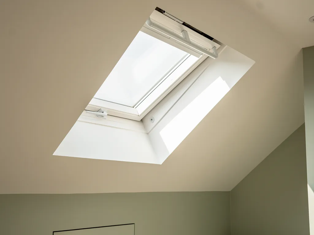A freshly plastered reveal around a roof window in a sloping ceiling